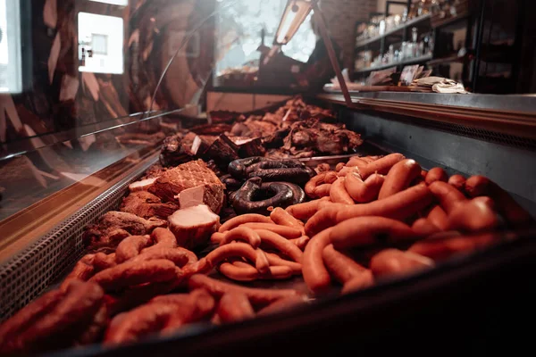 Fresh ham and sausages in meat shops counter — Stock Photo, Image