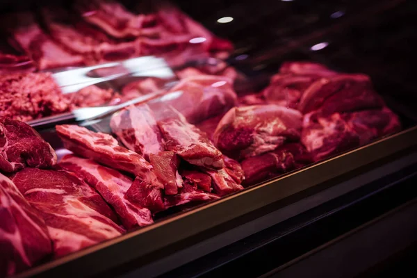 Diferentes tipos de carne rosada y fresca en la tienda — Foto de Stock