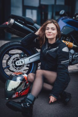 Şehirde güzel bir kadın ve spor motosikleti.