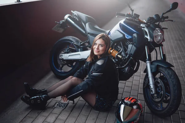 Brown motociclista cabelo feminino com sua poderosa motocicleta moderna — Fotografia de Stock