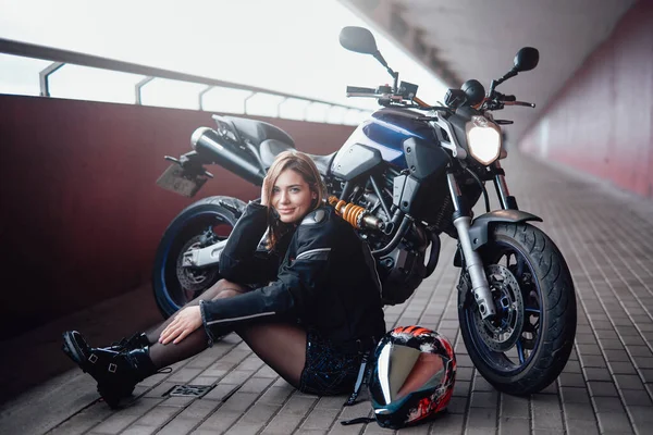 棕色头发的女自行车手，她的现代摩托车威力十足 — 图库照片