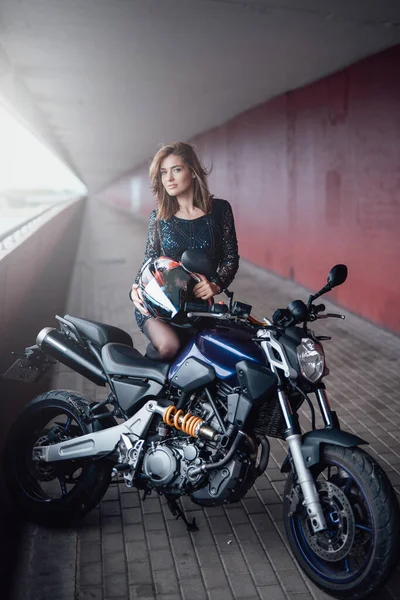 Una bella donna guidatrice con la sua moto sul ponte — Foto Stock