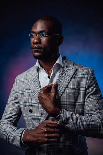 A charming serious black person with blue background behind