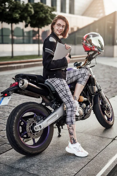 Sorridente bella ragazza su una moto sportiva elegante con il suo computer — Foto Stock