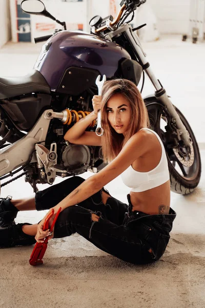 Menina bonita e bonito com chaves posando com uma motocicleta esporte — Fotografia de Stock