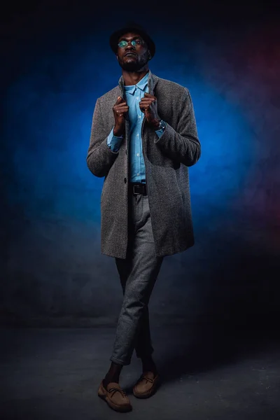 Well-dressed african hipster on foggy blue background — Stock Photo, Image