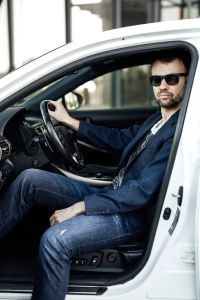 Um empresário adulto está sentado em seu carro novo — Fotografia de Stock