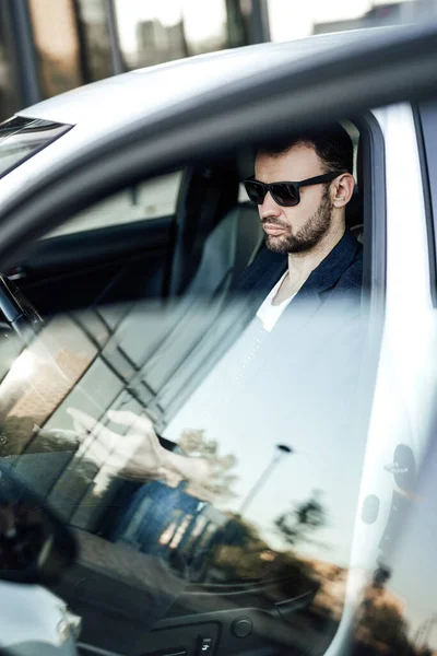 Un empresario dentro de su coche de conducción para hacer algunos tratos — Foto de Stock