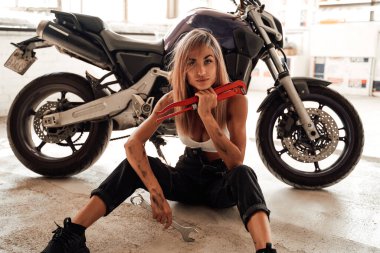 Parlak bir garaj ve içinde spor bisikleti olan bir kız.