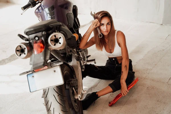 Feminino bonito técnico e moderno esporte moto na garagem brilhante — Fotografia de Stock