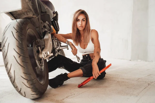 Garage drinnen und nettes Mädchen mit benutzerdefinierten Motorrad — Stockfoto