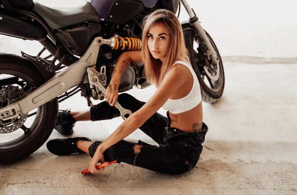 Garagem dentro de casa e menina bonito com moto personalizada — Fotografia de Stock