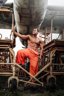 Güçlü bir adam ve arkasında kocaman bir uçak türbini var.