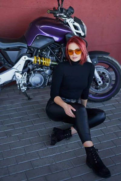 Mignonne rousse femme assise et posant avec sa moto — Photo