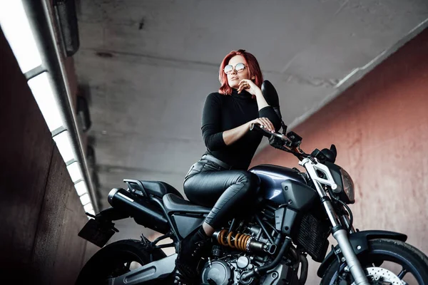 Menina de beleza com óculos monta sua bicicleta na ponte — Fotografia de Stock