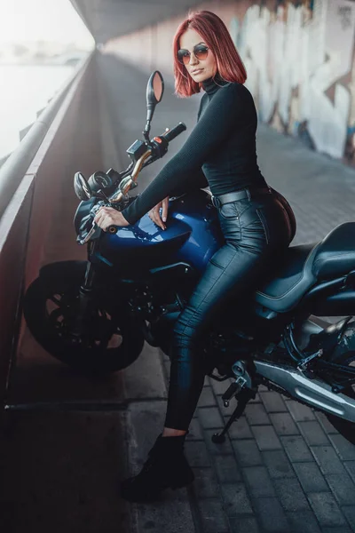 Ein modernes Motorrad und eine Motorradfahrerin mit roten Haaren — Stockfoto