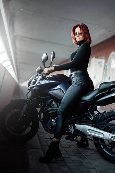 A modern motorbike and female biker with red hairs — Stock Photo, Image