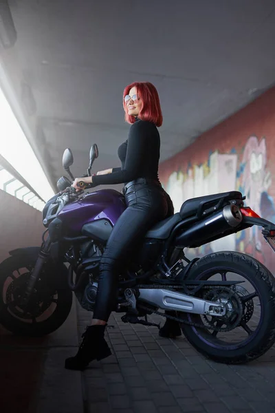 Uma moto moderna e motociclista feminina com cabelos vermelhos — Fotografia de Stock