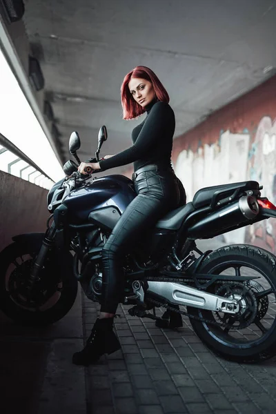Рыжая сексуальная байкер ездит на своем современном мотоцикле — стоковое фото