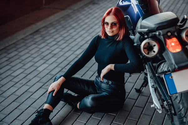 Słodkie ruda kobieta siedzi i pozowanie z jej motocykl — Zdjęcie stockowe