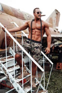 Bronzlaşmış şapkalı çıplak adam terk edilmiş uçak muhafızları.