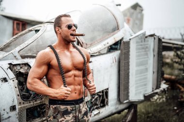 Bronzlaşmış şapkalı çıplak adam terk edilmiş uçak muhafızları.