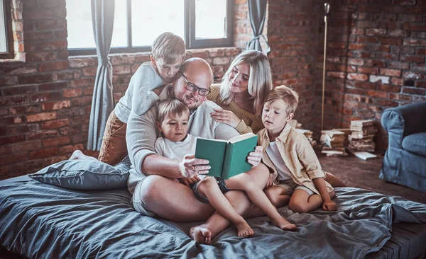 Meninos felizes e seus pais lendo conto de fadas no hotel — Fotografia de Stock