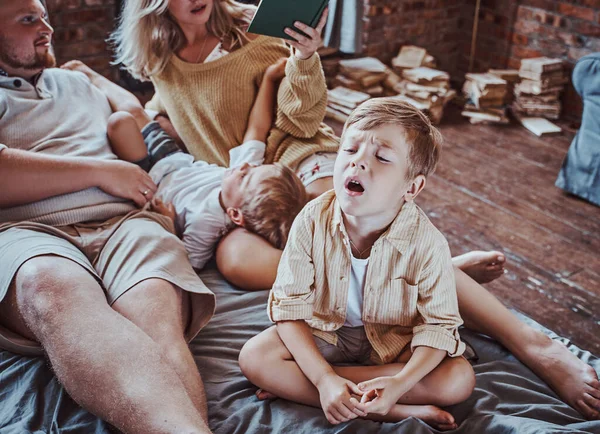 Pais positivos descansando na sala de estar com seus meninos — Fotografia de Stock