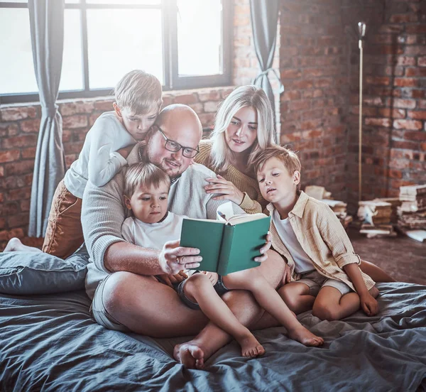 Pais positivos descansando na sala de estar com seus meninos — Fotografia de Stock