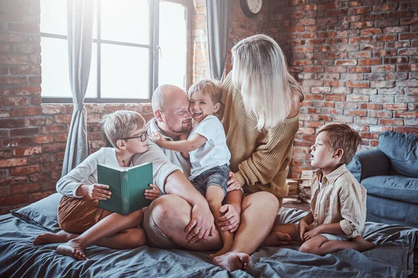 Irmãos alegres e seu pai e mãe em casa — Fotografia de Stock
