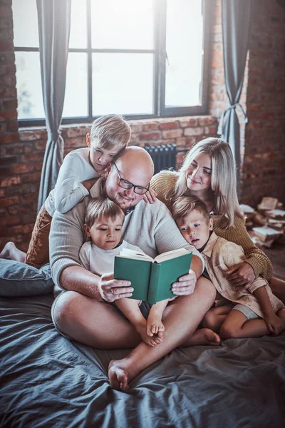 Happy boys and their parents reading fairytale in hotel — Stock Photo, Image