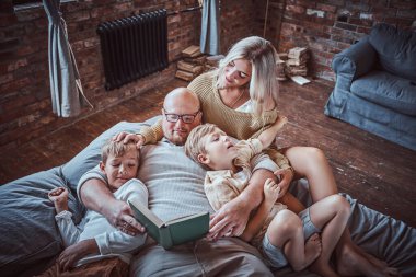 Ebeveynler çocuklarına oturma odasında okumayı öğretiyor.