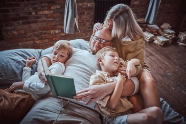 Ebeveynler çocuklarına oturma odasında okumayı öğretiyor.