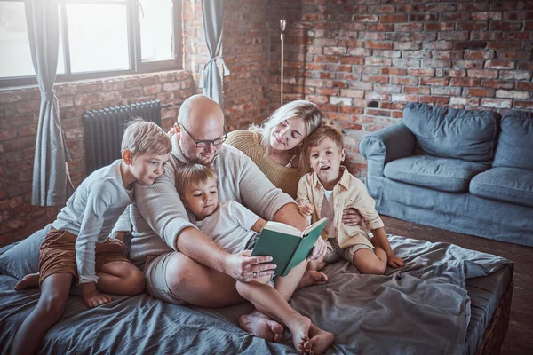 Irmãos alegres e seu pai e mãe em casa — Fotografia de Stock