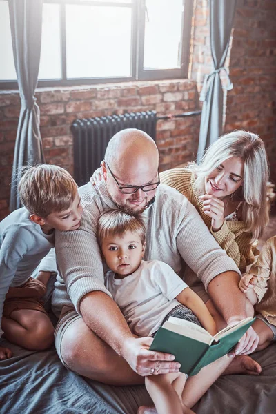 Happy boys and their parents reading fairytale in hotel — Stock Photo, Image