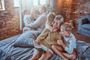 Ebeveynler çocuklarına oturma odasında okumayı öğretiyor.