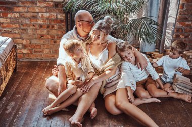 Amerikalı neşeli aile yerde oturup kitap okuyor.