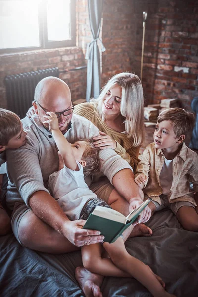 Pais positivos descansando na sala de estar com seus meninos — Fotografia de Stock