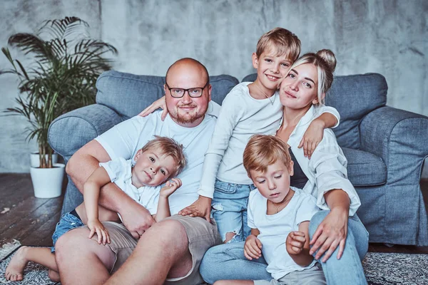 Mãe e pai com seus meninos sentados no chão — Fotografia de Stock