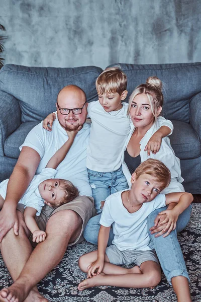 Mor och far med sina pojkar sittande på golvet — Stockfoto
