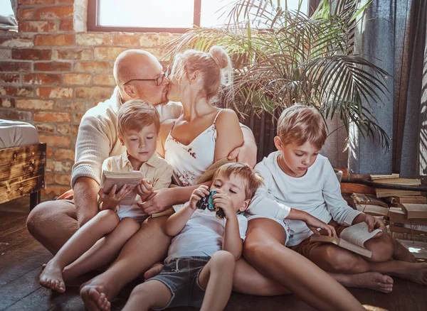 American alegre família sentada no chão e lendo livros — Fotografia de Stock