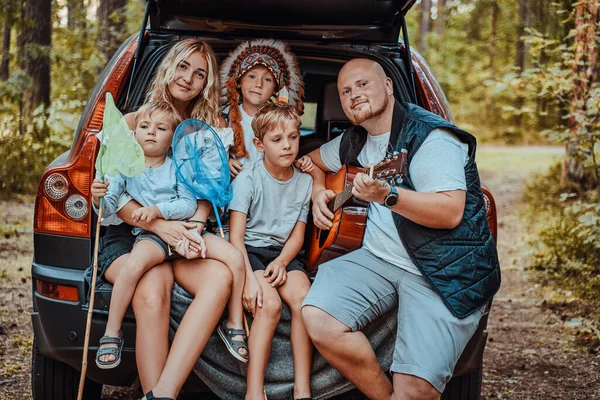 Amerikaanse vrouw en man met kinderen in auto — Stockfoto