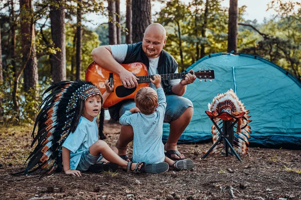 Padre americano enseñando a sus chicos a tocar la guitarra — Foto de Stock