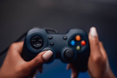 Afro kızın güzel elleri arka planda küçük bir joystick tutuyor.