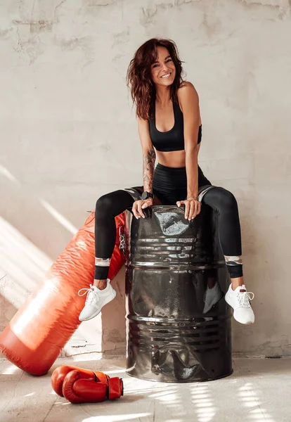 Positive Sportlerin ruht nach hartem Training in Garage — Stockfoto