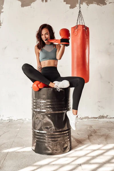 Boxerin sitzt auf Tonne im Trainingsraum — Stockfoto