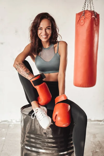 Boxer femminile seduto su un barile in sala di allenamento — Foto Stock