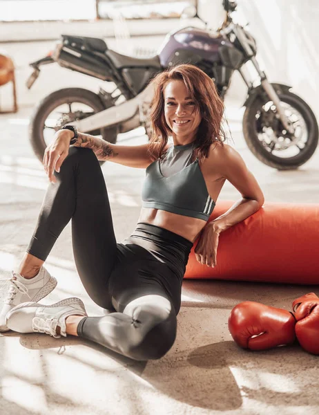 Menina bonita com seu equipamento esportivo e moto — Fotografia de Stock