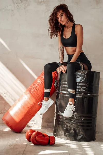 Positive sport girl resting after hard training in garage — Stock Photo, Image
