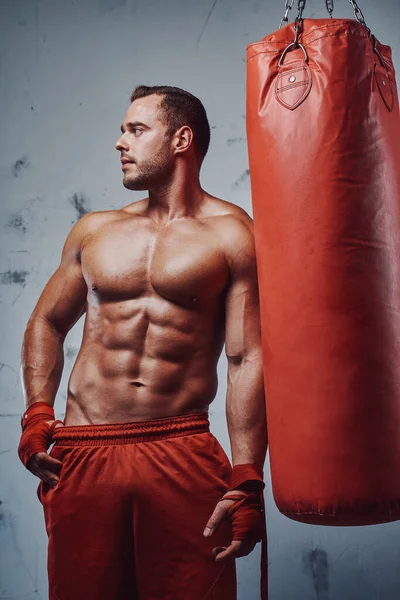 М'язистий боксер з голим тренуванням тулуба з мішком для ударів — стокове фото
